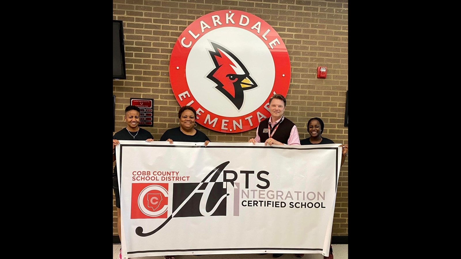 3 women and 1 man holding up a banner that says Cobb County School District Arts Integration Certified School
